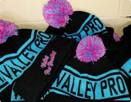 a couple of pom pom beanies that have are pink and blue in colour